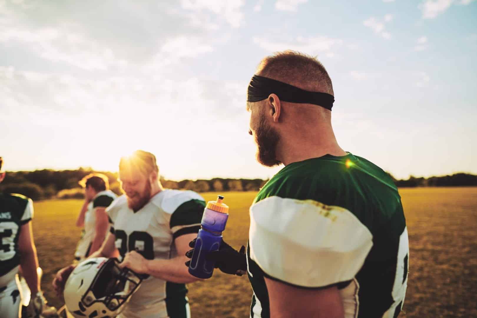 American football players talking together on field after practice